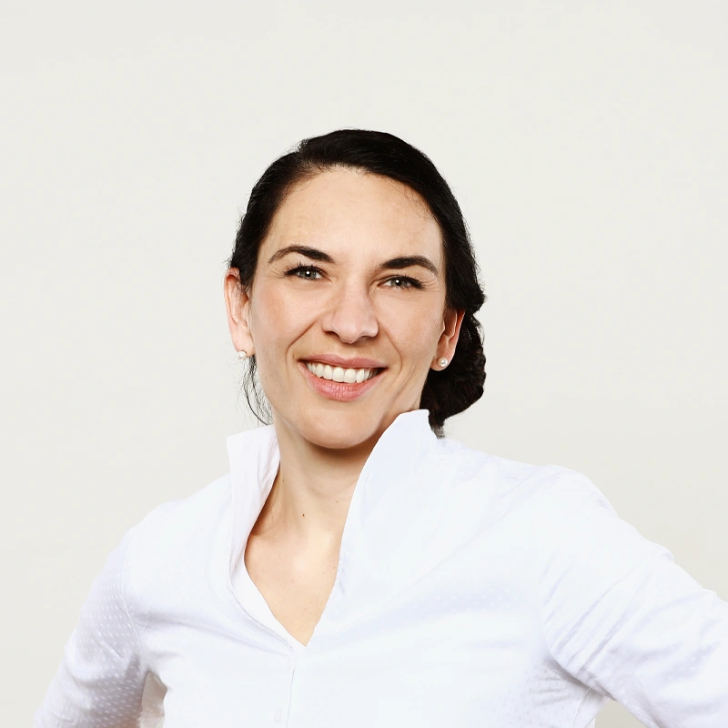 Porträt von Frau Szabadi in weißer Bluse – erfahrene Zahnärztin mit Spezialisierung auf moderne und ganzheitliche Zahnmedizin.