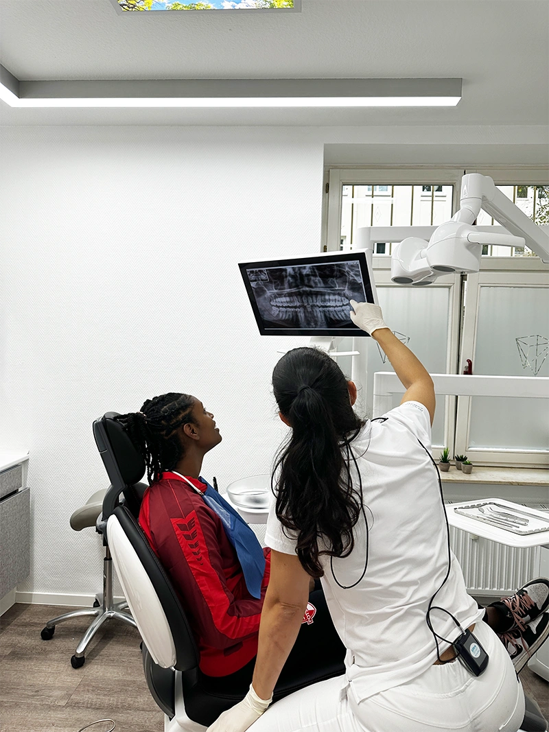 Zahnärztin erklärt Patientin das Röntgenbild im Rahmen Zahnärztin erklärt einer Patientin das digitale Röntgenbild und berät sie ausführlich zur Zahnprophylaxe in der Zahnarztpraxis Szabadi.