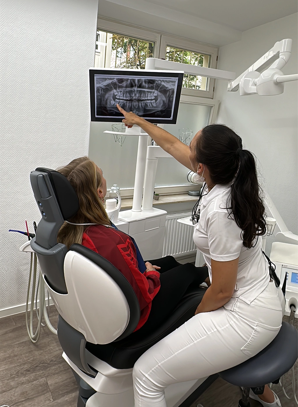 Zahnärztin erklärt Patientin anhand eines digitalen Röntgenbilds die individuelle Behandlung im Bereich zahnärztliche Prophylaxe in der Zahnarztpraxis Szabadi.